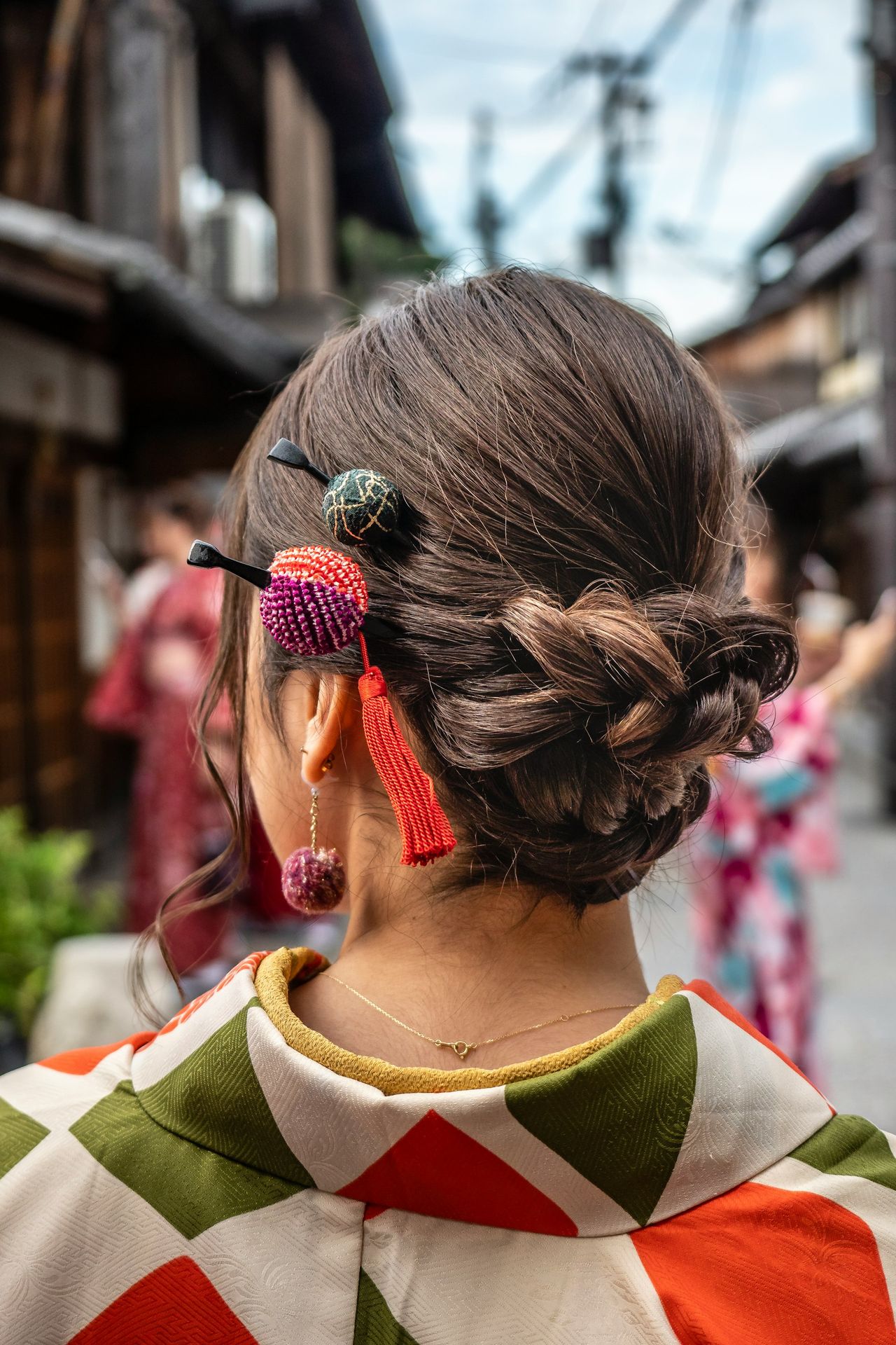 woman in green and white shirt with black and red floral hair tie